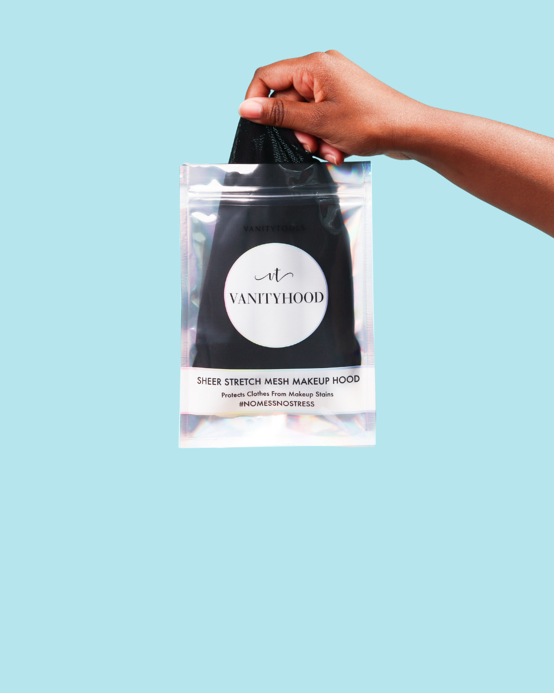 Hand holding a black makeup hood product